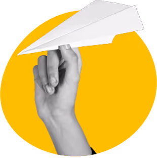 Hand holding a white paper airplane against a yellow circular background.